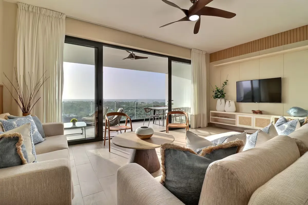 Living room framed by floor-to-ceiling doors opening onto the ocean terrace