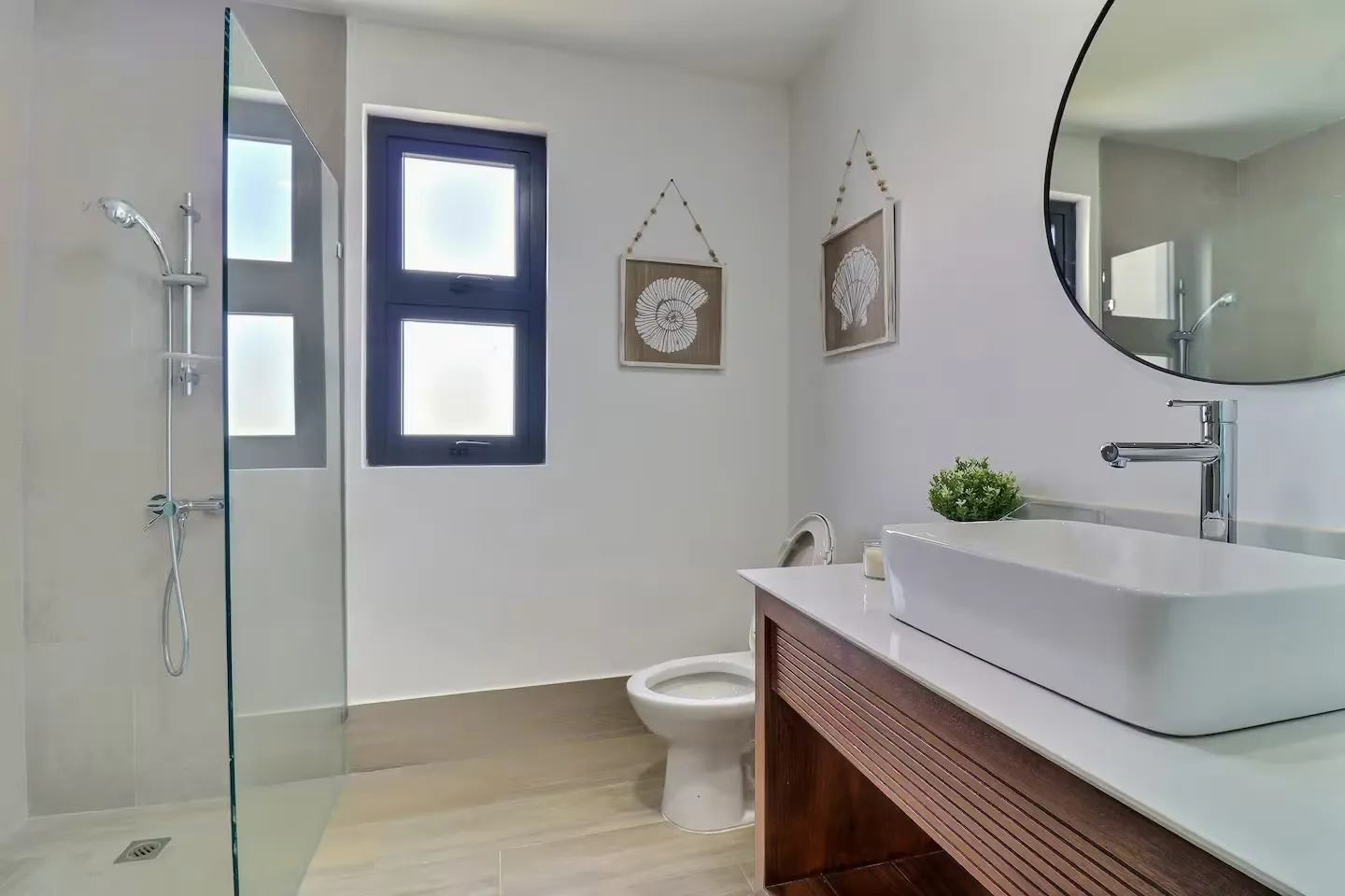 Walk-in shower with glass enclosure and sea-inspired art