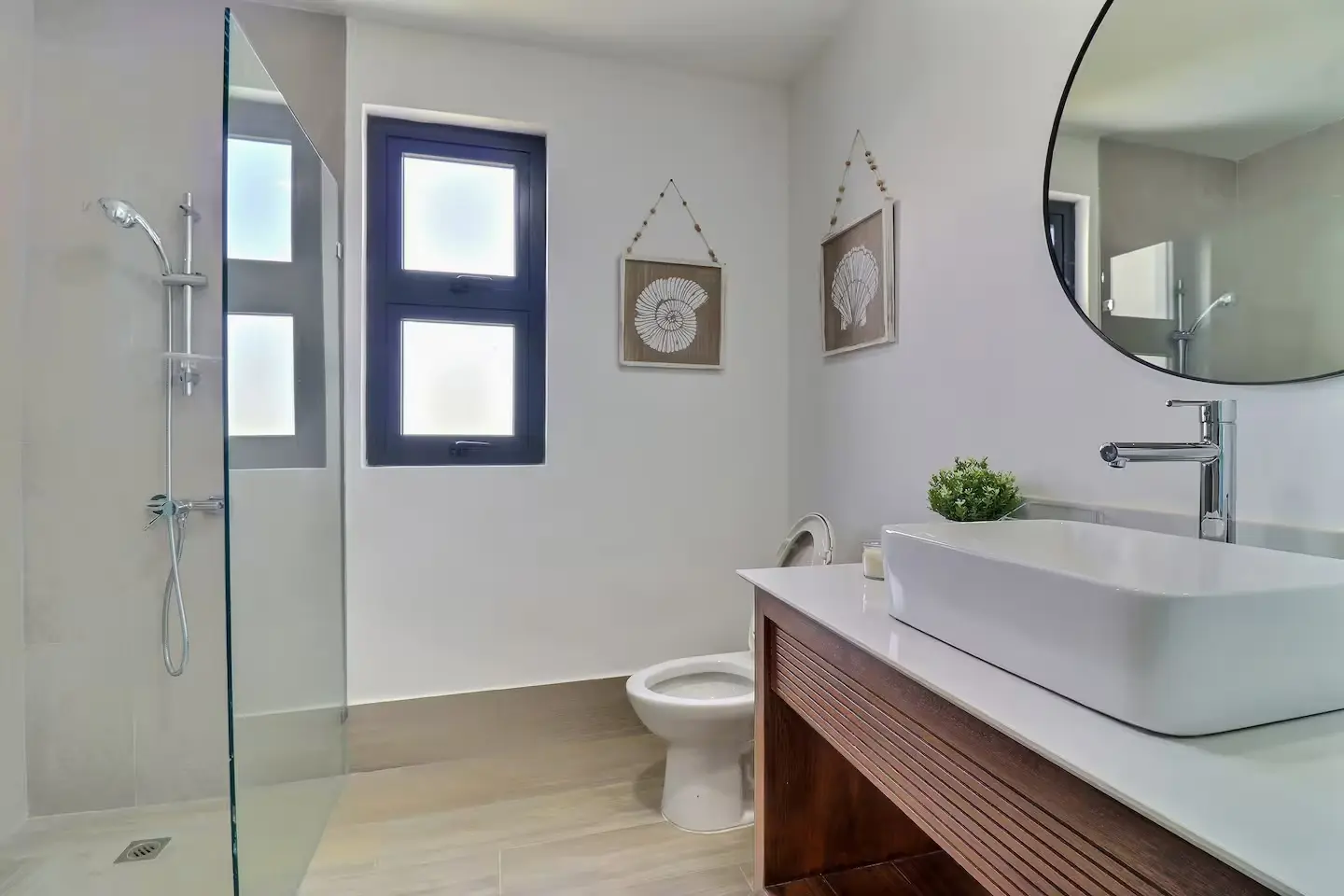 Walk-in shower with glass enclosure and sea-inspired art