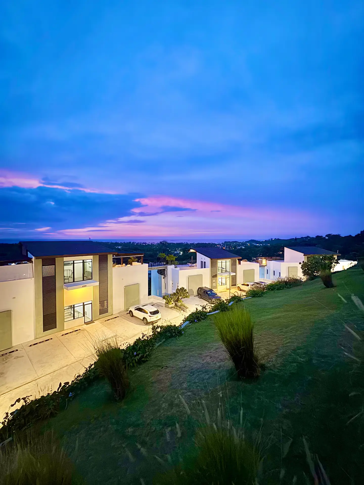The residence building seen from the grounds at golden hour